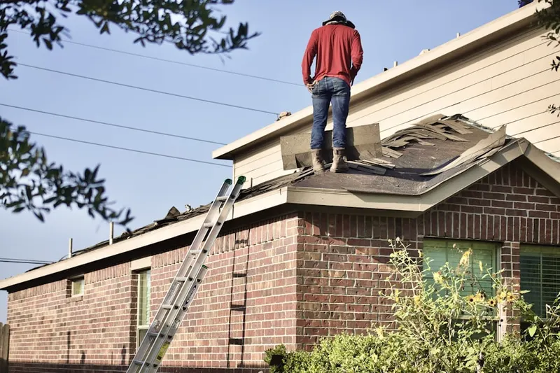Professional roofer working on a residential roof in Hard Cash